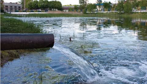 wastewater streaming from pipe into pond